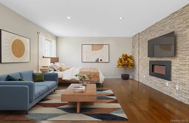a view of an empty room with wooden floor and a fireplace