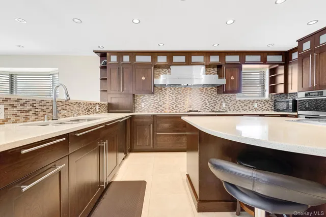 a kitchen with stainless steel appliances granite countertop a stove a sink and a microwave