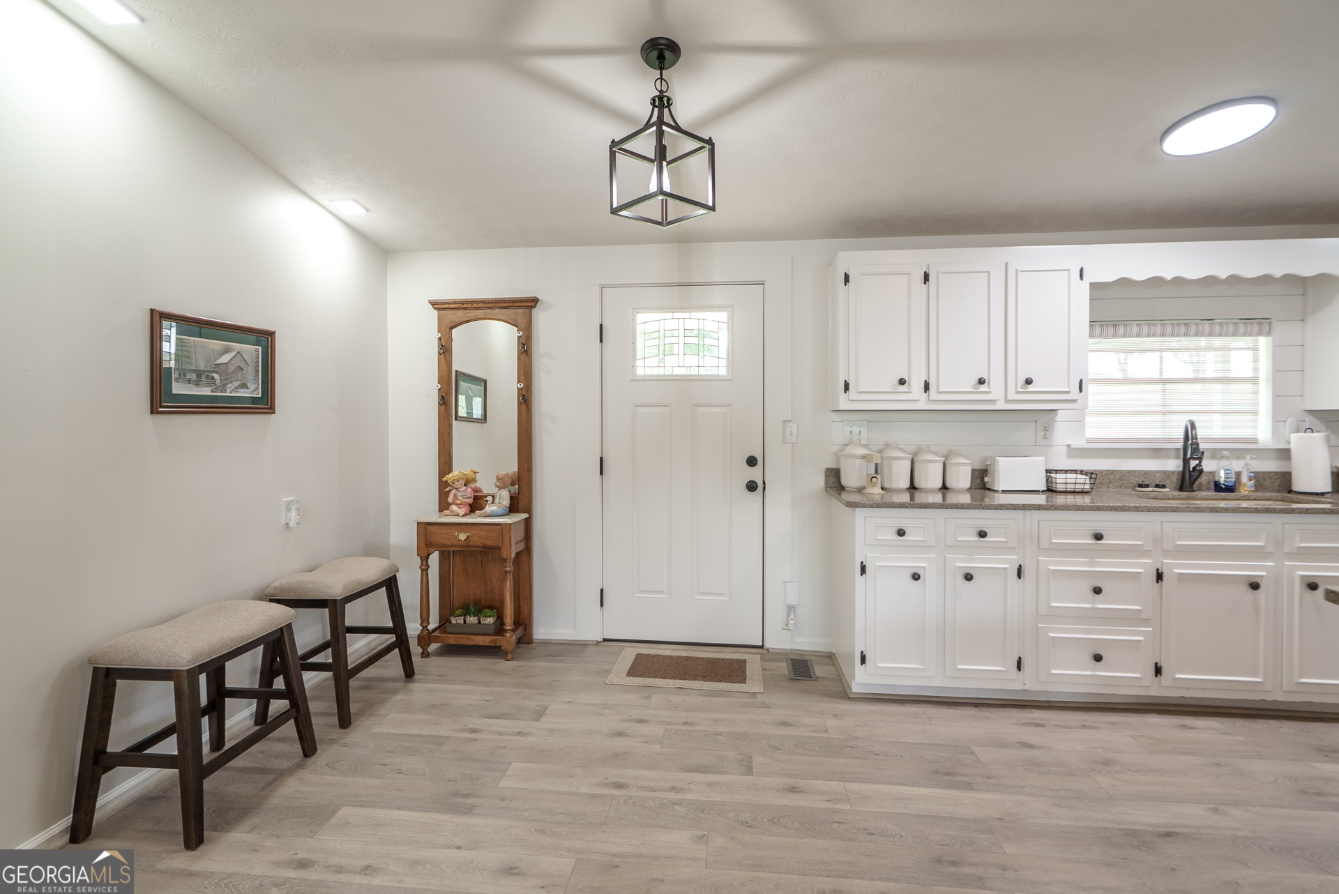 1180 Greenbriar Drive Madison, GA 30650 - Photo 25 of 54 a kitchen with granite countertop a stove cabinets and chairs