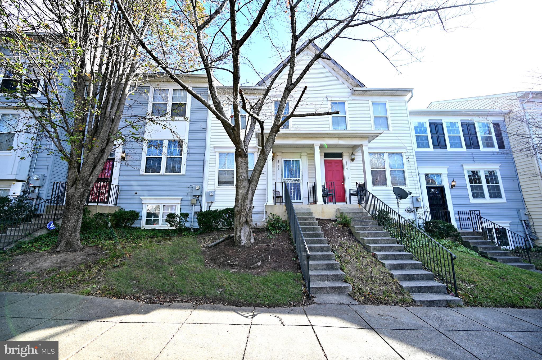 a front view of a house with a yard and trees