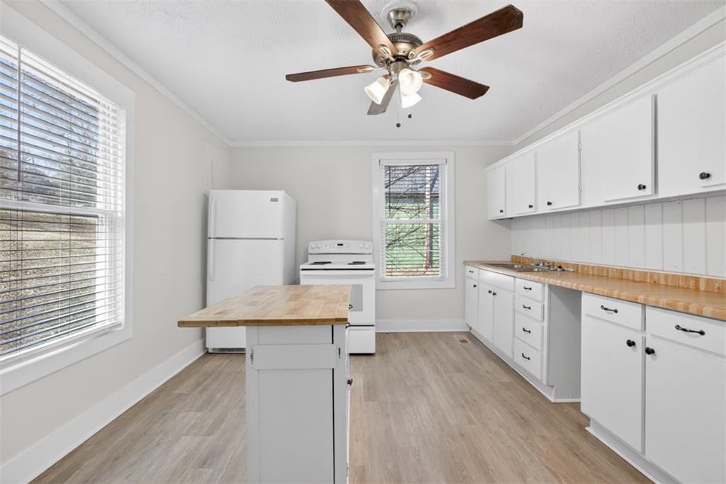 246 Spring Street Commerce, GA 30529 - Photo 8 of 23 a kitchen with cabinets wooden floor and a window