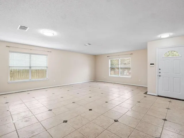 a view of an empty room with a fireplace and a window