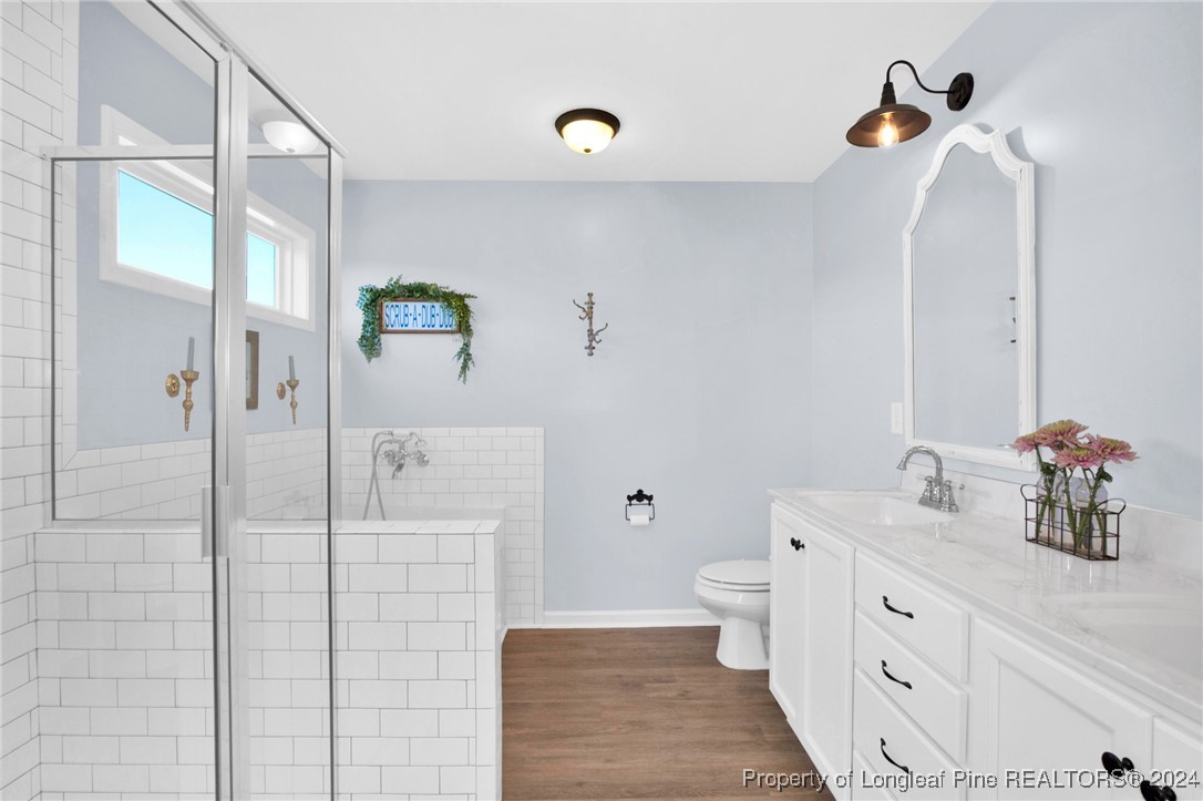 11 Rainmaker Street Linden, NC 28356 - Photo 15 of 32 a bathroom with a double vanity sink a toilet and shower
