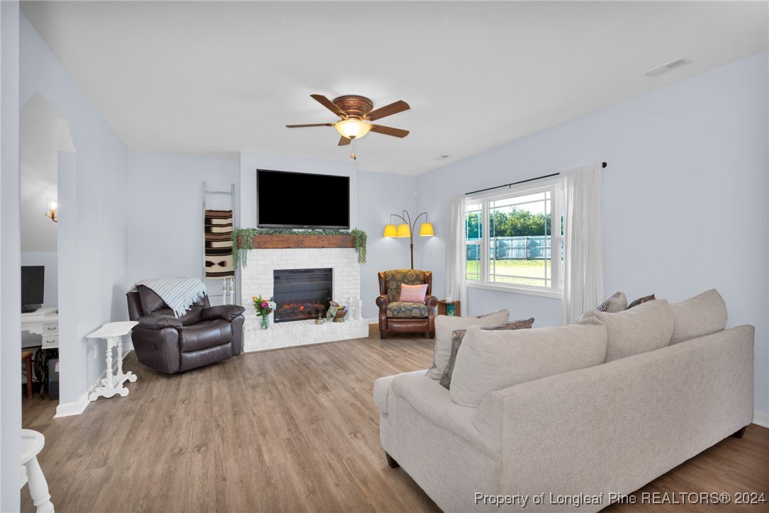 11 Rainmaker Street Linden, NC 28356 - Photo 6 of 32 a living room with furniture a flat screen tv and a fireplace
