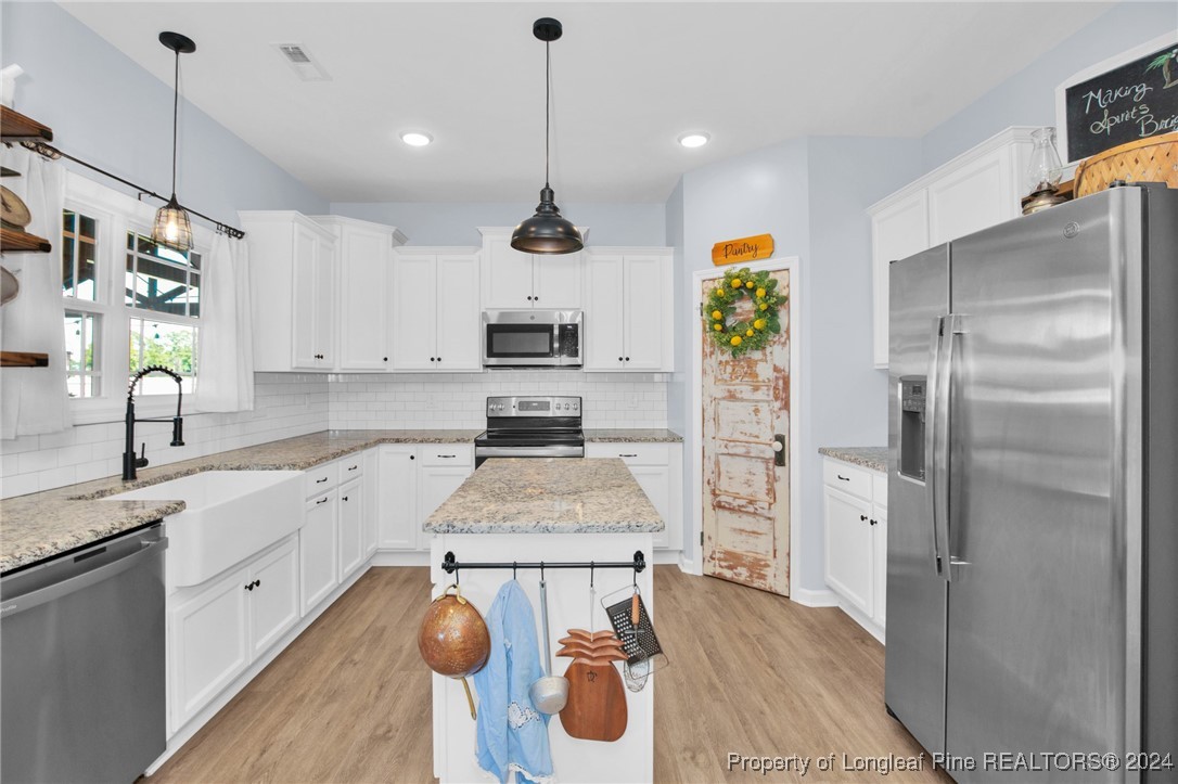 11 Rainmaker Street Linden, NC 28356 - Photo 8 of 32 a kitchen with stainless steel appliances granite countertop a refrigerator a sink dishwasher a stove and white cabinets with wooden floor