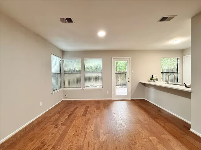 a view of empty room with wooden floor