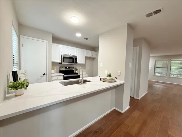 a view of kitchen with refrigerator cabinets and window