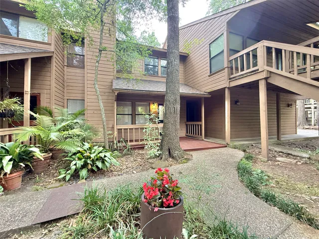 a front view of a house with a yard and potted plants