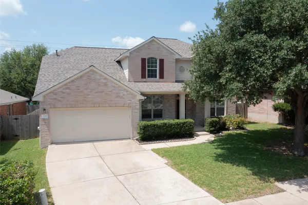 a front view of a house with a yard and trees