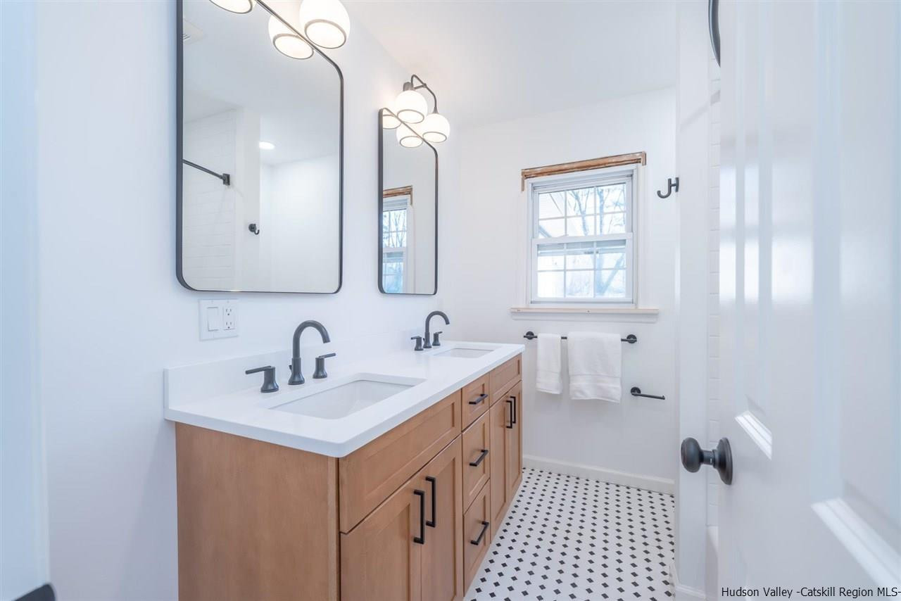 20 Robin Lane Kingston, NY 12401 - Photo 22 of 35 a bathroom with a double vanity sink a mirror and a bathtub