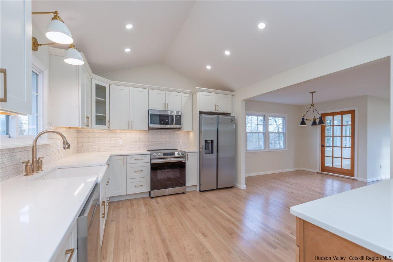 20 Robin Lane Kingston, NY 12401 - Photo 6 of 35 a large kitchen with stainless steel appliances granite countertop a refrigerator a sink dishwasher a stove and a dining table with wooden floor