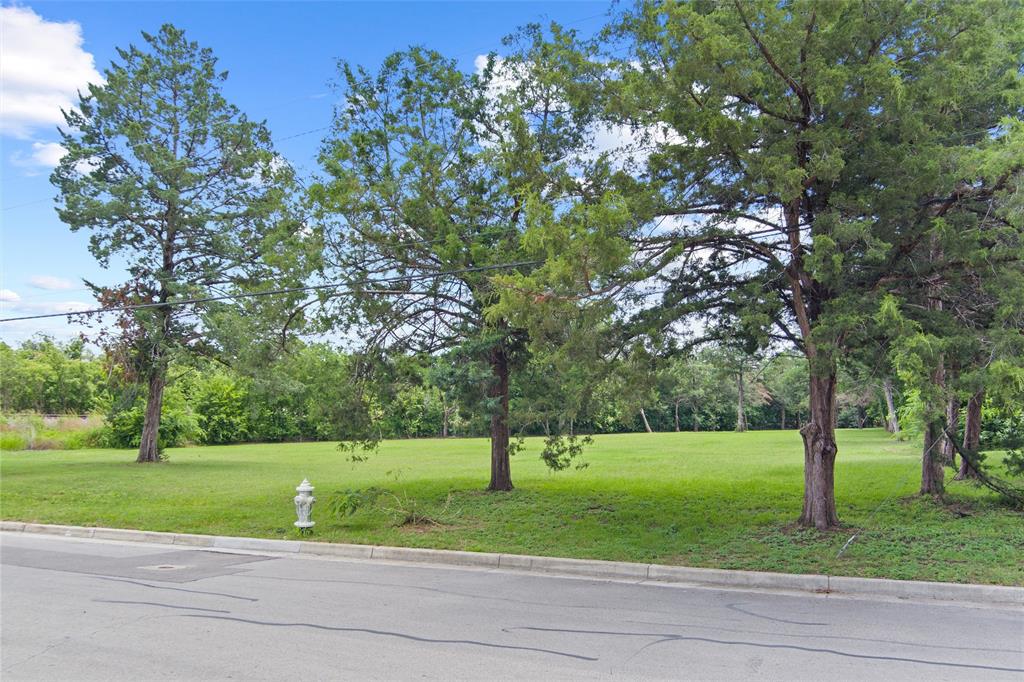 a view of a house with a big yard and large trees