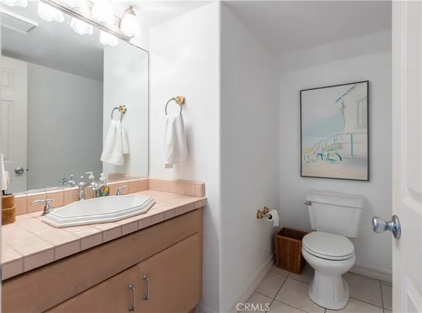 a bathroom with a granite countertop toilet sink and mirror