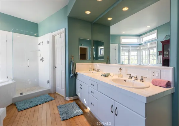 a bathroom with a double vanity sink mirror and shower