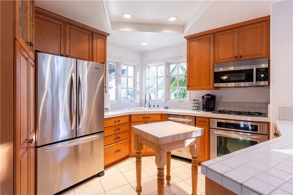 a kitchen with stainless steel appliances a refrigerator sink and microwave