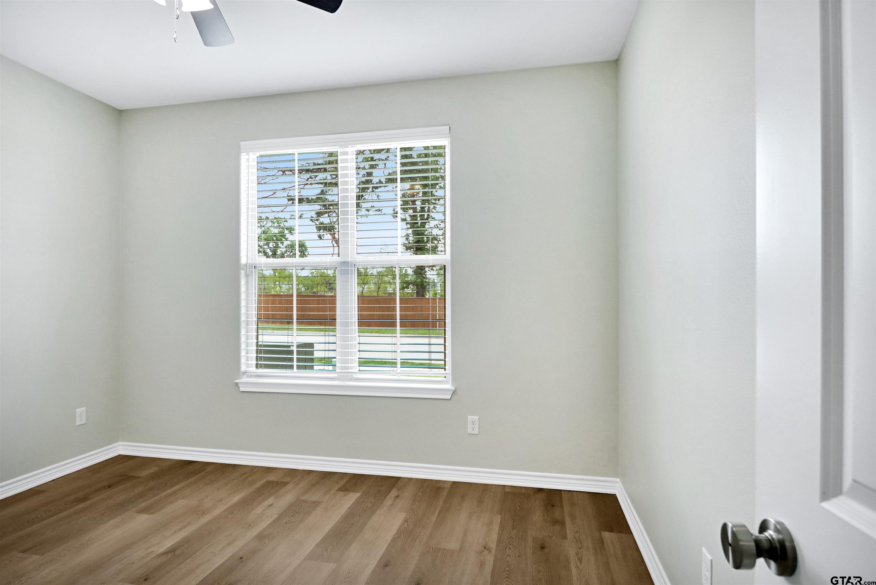 3053 Guinn Farms Road Tyler, TX 75707 - Photo 24 of 32 an empty room with wooden floor and windows