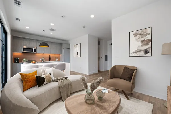 a living room with furniture and a view of kitchen