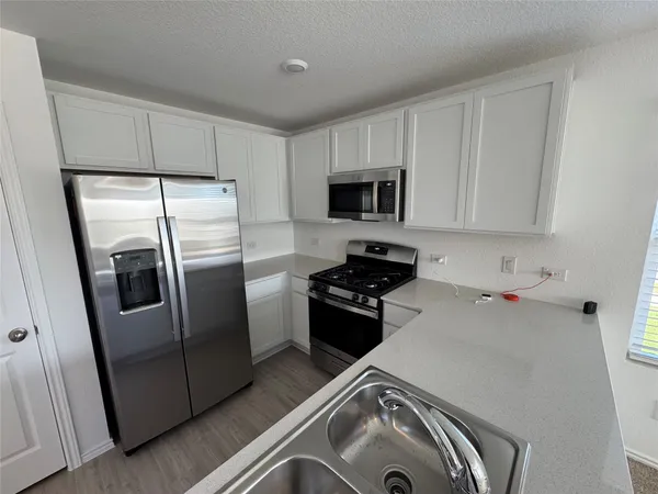 a view of a kitchen with microwave and windows