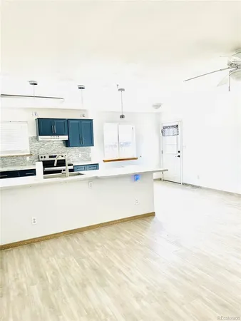 a kitchen with stainless steel appliances a refrigerator a stove top oven and white cabinets