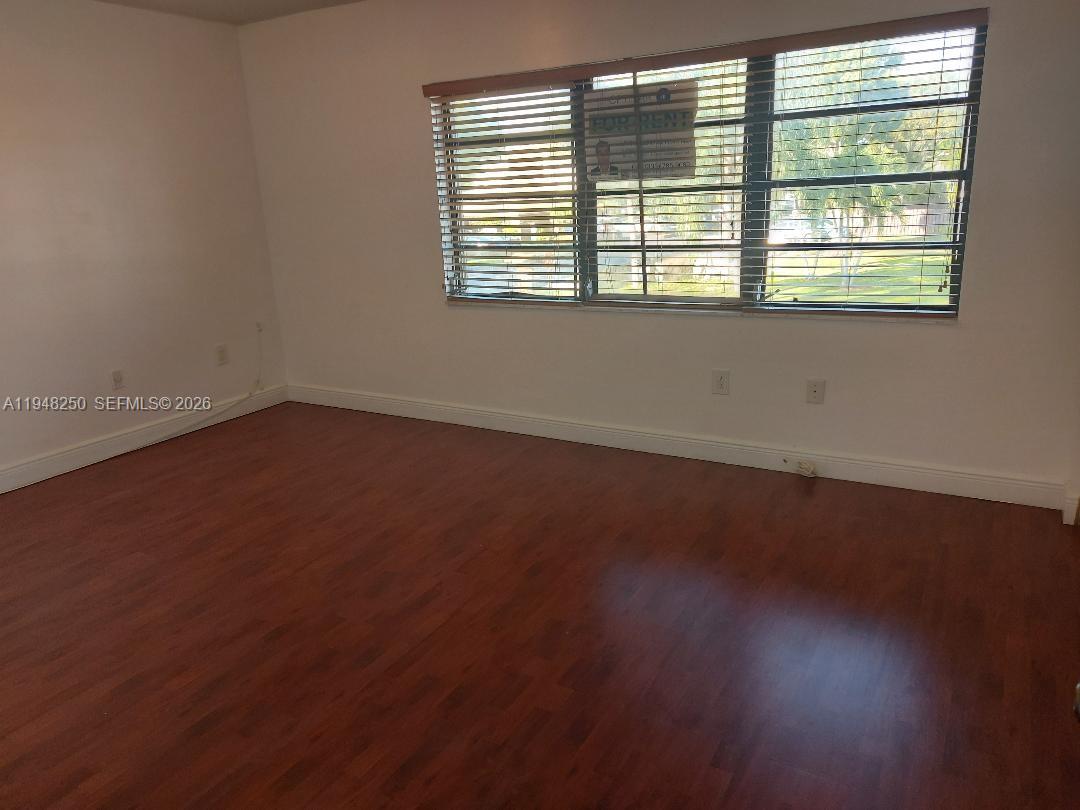 20033 Northeast 2nd Place Miami, FL 33179 - Photo 14 of 23 an empty room with wooden floor and windows