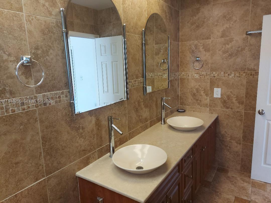 20033 Northeast 2nd Place Miami, FL 33179 - Photo 9 of 23 a bathroom with a sink and a mirror