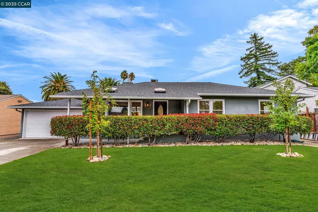 a front view of a house with a garden