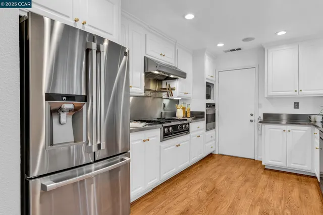 a kitchen with a refrigerator a sink and cabinets