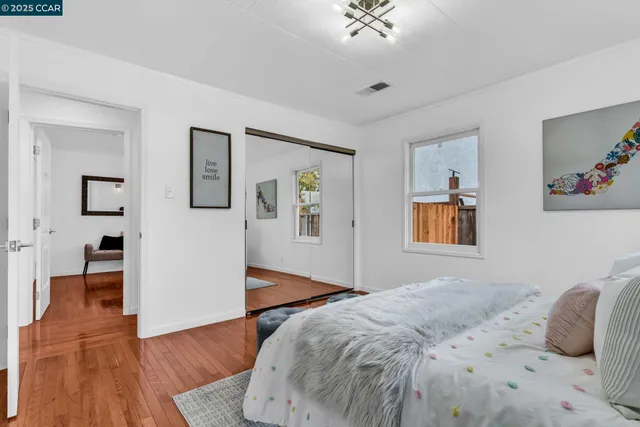 a bedroom with a bed and painting on the wall