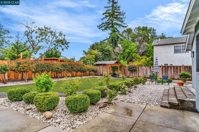 a row of potted plants and a bench in front of a house