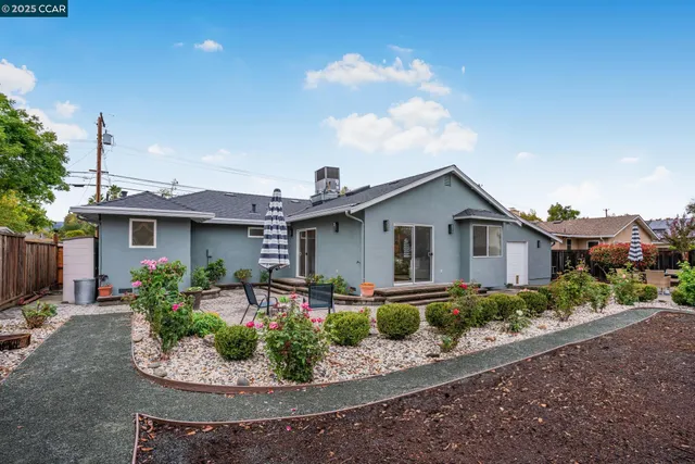 a front view of a house with a yard and potted plants