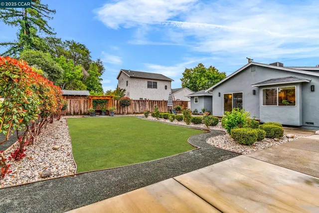a front view of a house with a yard and potted plants