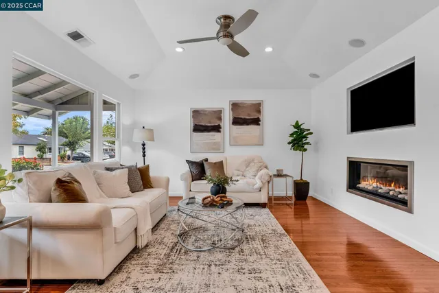 a living room with furniture a flat screen tv and a fireplace