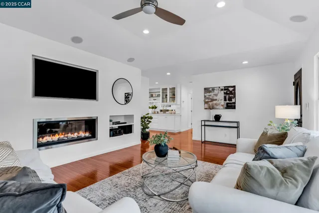 a living room with furniture a flat screen tv and a fireplace