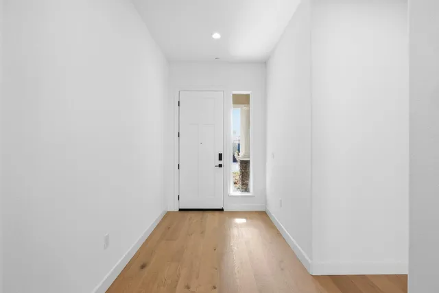 a view of kitchen with refrigerator stove and white cabinets