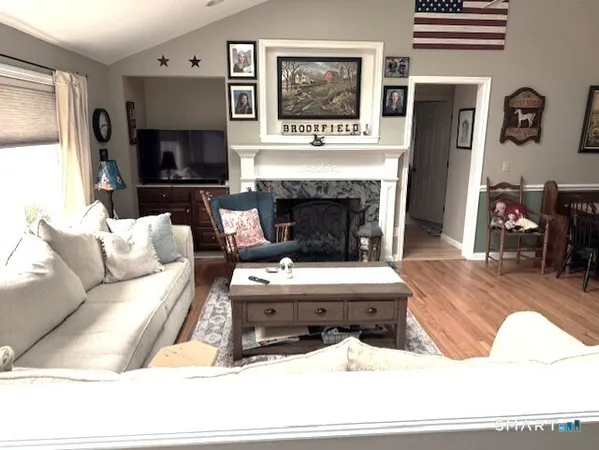 a living room with furniture a flat screen tv and a fireplace