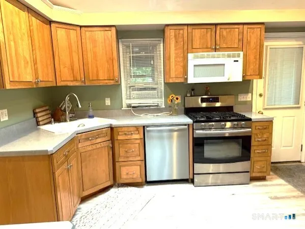 a kitchen with stainless steel appliances a stove a sink and a microwave
