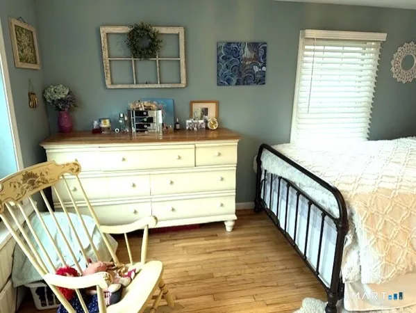 a bedroom with a bed and wooden floor