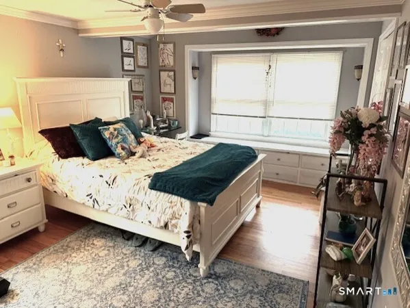 a white bed sitting in a bedroom next to a window