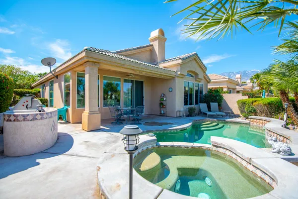 a view of a house with backyard water fountain and sitting area