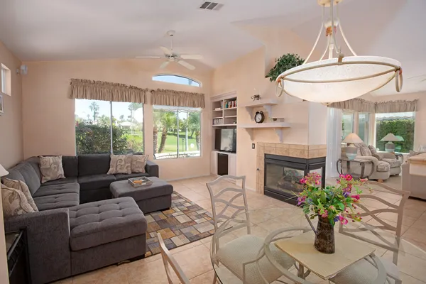 a living room with furniture a fireplace and kitchen view