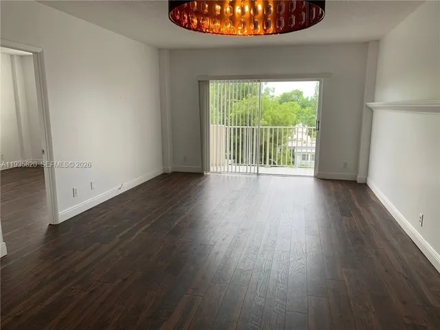 a view of a room with wooden floor and a floor to ceiling window