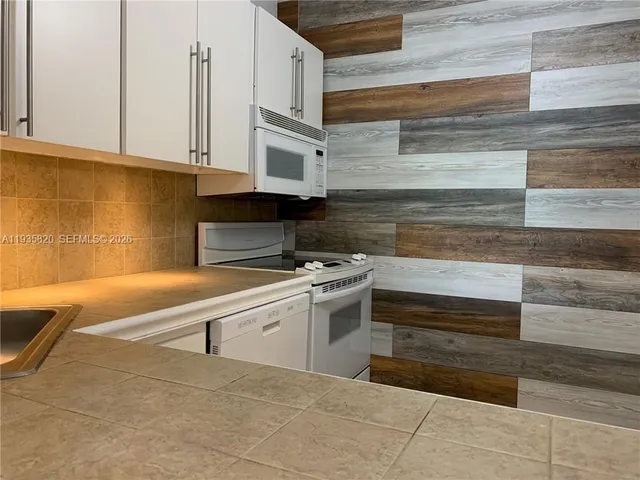 a view of a kitchen with stove and cabinets