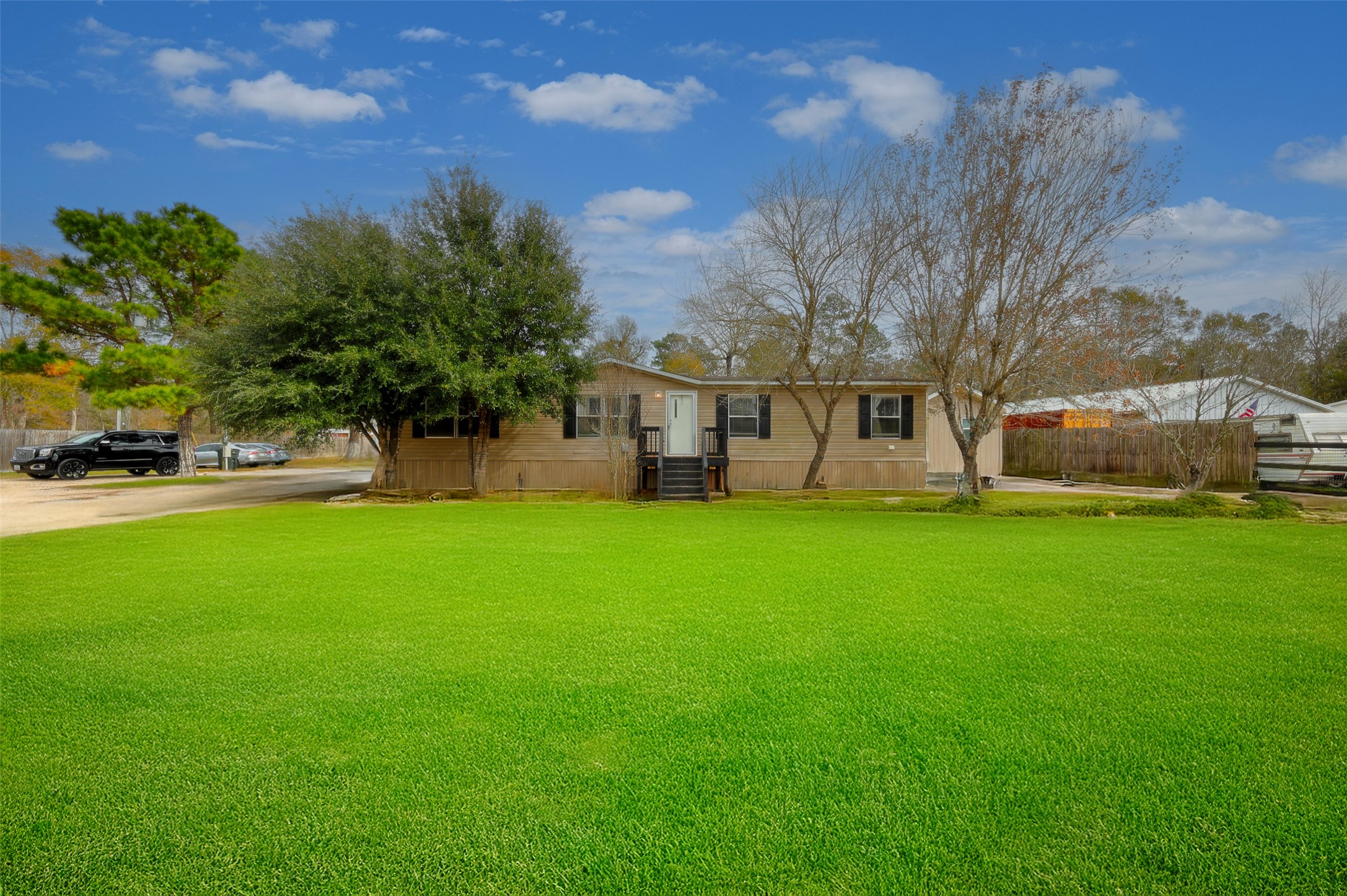2373 Crockett Martin Road Conroe, TX 77306 - Photo 2 of 34 This photo shows a single-story manufactured home with a neutral exterior and black shutters.
