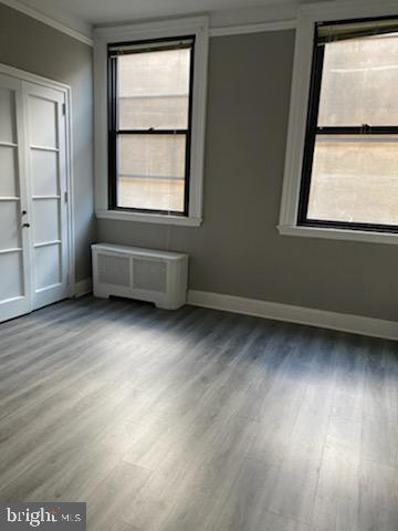 2031 Locust Street, Unit 103 Philadelphia, PA 19103 - Photo 2 of 16 an empty room with wooden floor and windows