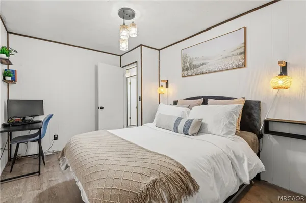 a bedroom with a large bed and a lamp on dresser