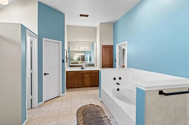 a spacious bathroom with a tub shower and sink