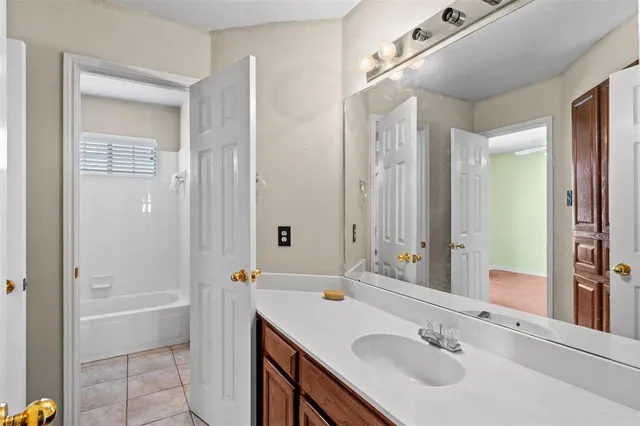 a bathroom with a bath tub sink mirror and shower