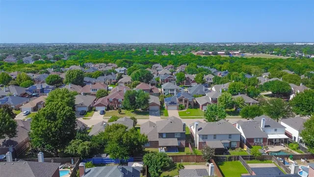 an aerial view of residential houses with outdoor space and trees