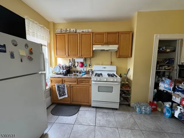 a kitchen with a refrigerator and white cabinets