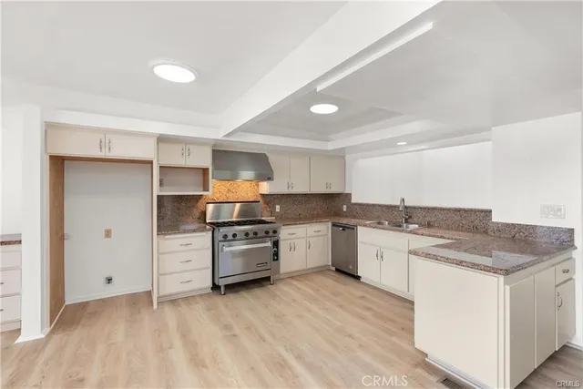 a kitchen with granite countertop a stove top oven sink and cabinets
